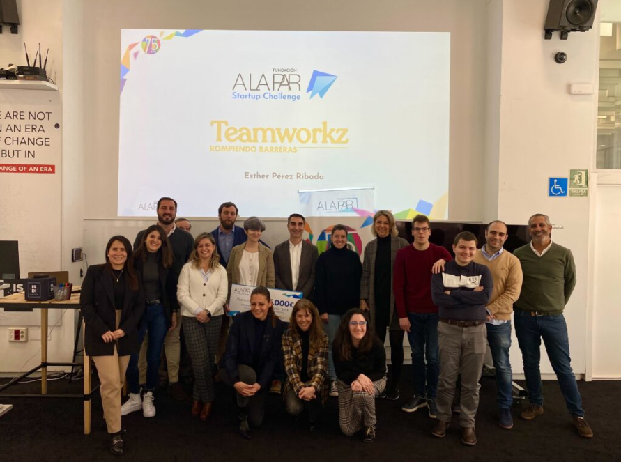 Un grupo de unas quince personas posa para una foto grupal en un evento de la Fundación A LA PAR. Al fondo, una pantalla de proyección muestra el título 